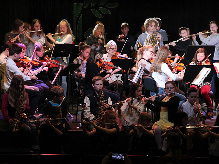 En stor orkester bestående av blås- och stråkelever, spelar på en scen. Foto: Victoria Eriksson, 2018